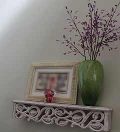 A narrow shelf for displaying picture frames and small objects