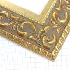 A large, reverse curve profile frame with an intricate leaf design bordered by a geometric outer edge and beaded inner lip.  A matte and gold foil base features bronze patina for added depth on the topmost points of the design. Strong, solid wood construction.

3.25 " width: ideal for large and extra large images.